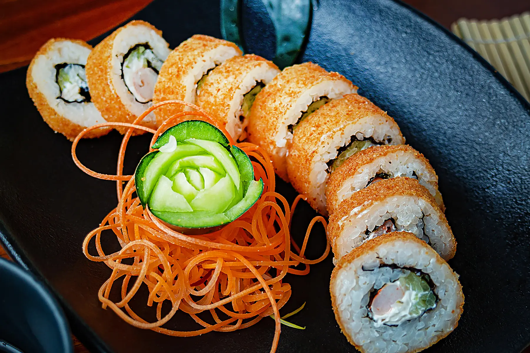 Sushi empanizado con pepino, camarón y philadelphia por dentro con zanahoria rayada y una flor echa con pepino de Sushi Market del hotel Sunset Palace Mazatlán