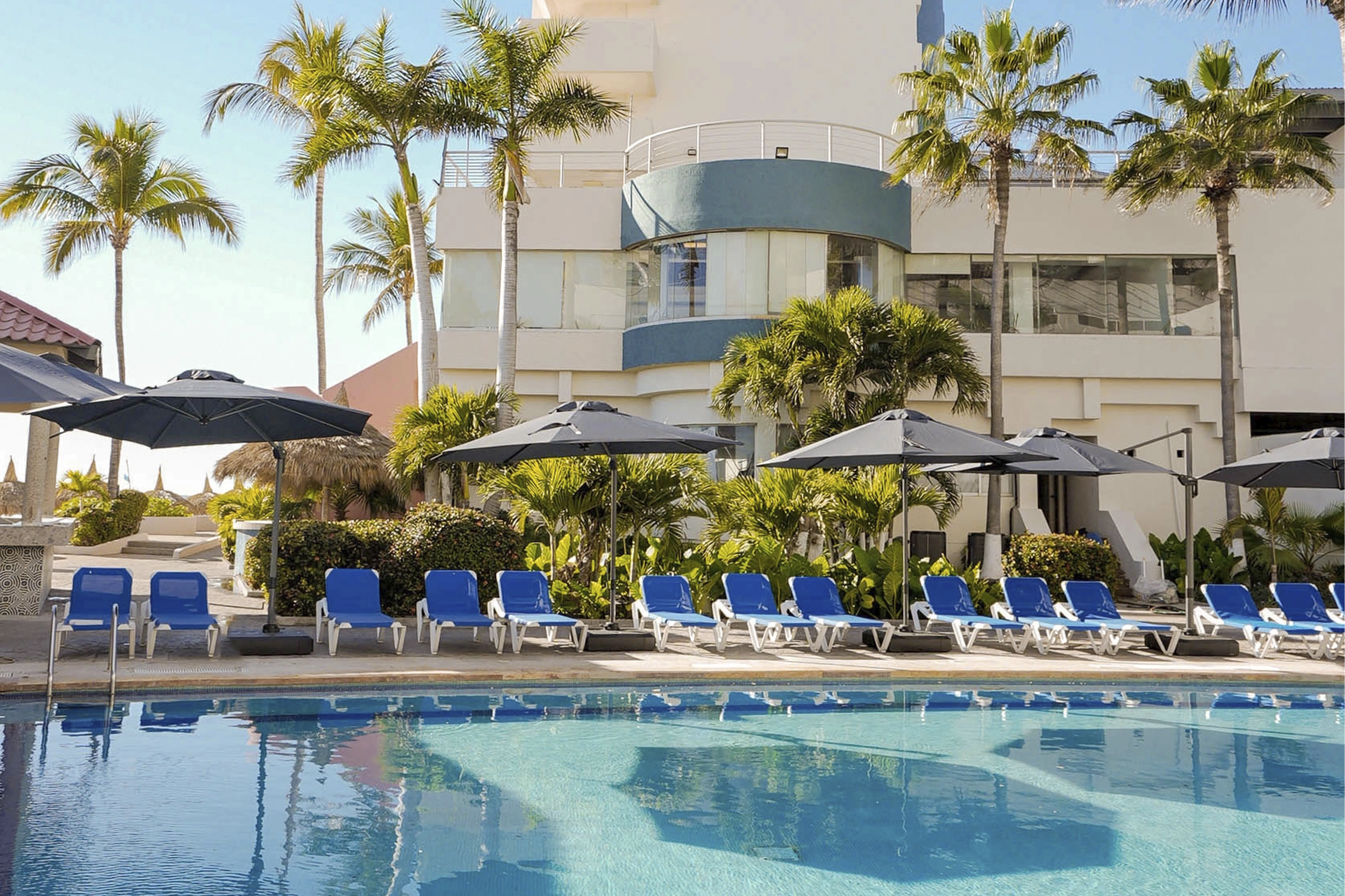 Vista panoramica de alberca y fachada frente a Hotel Sunset Mazatlan