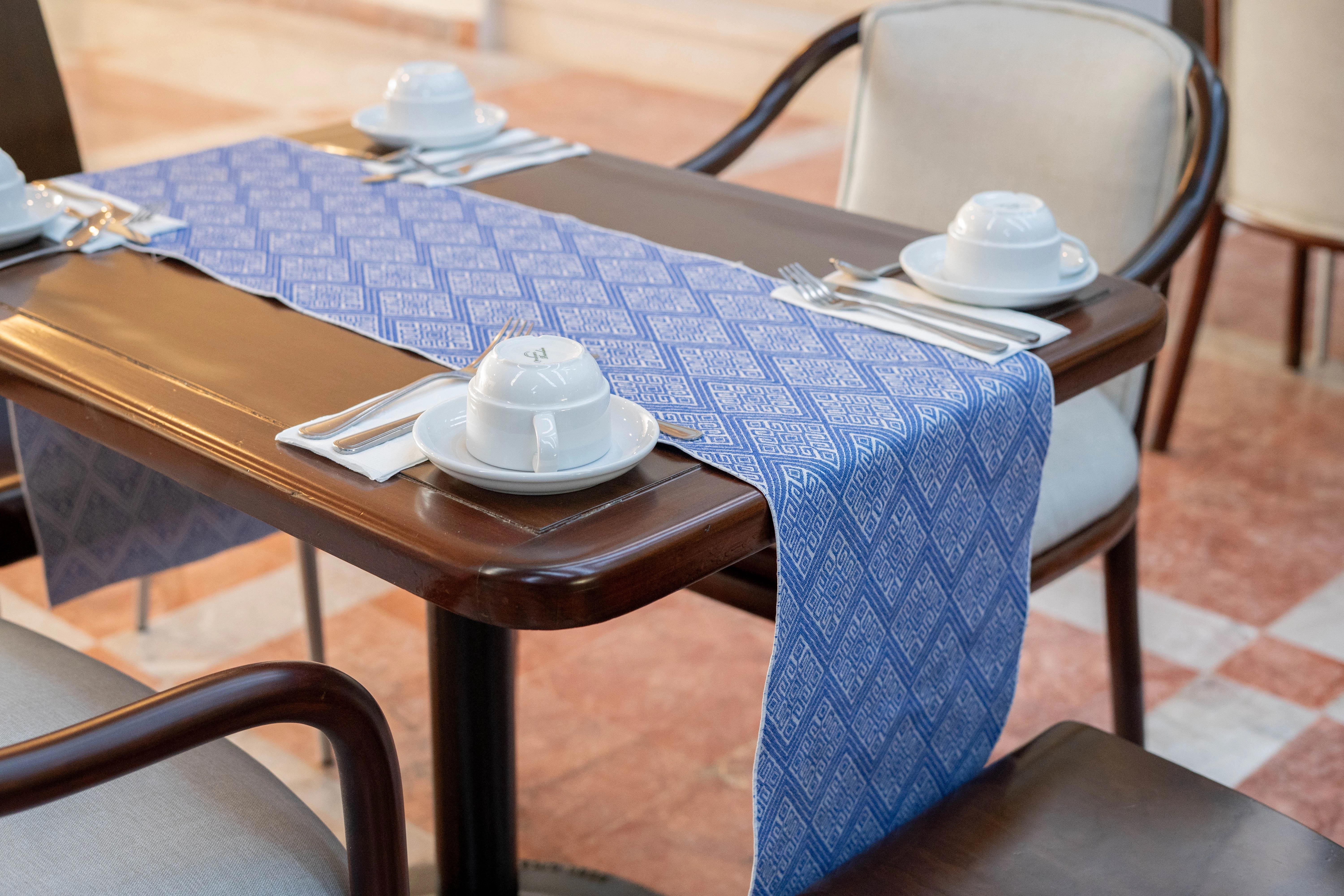 Detalles de mesa, platos y mantel de restaurante Horizonte en Hotel Sunset Palace