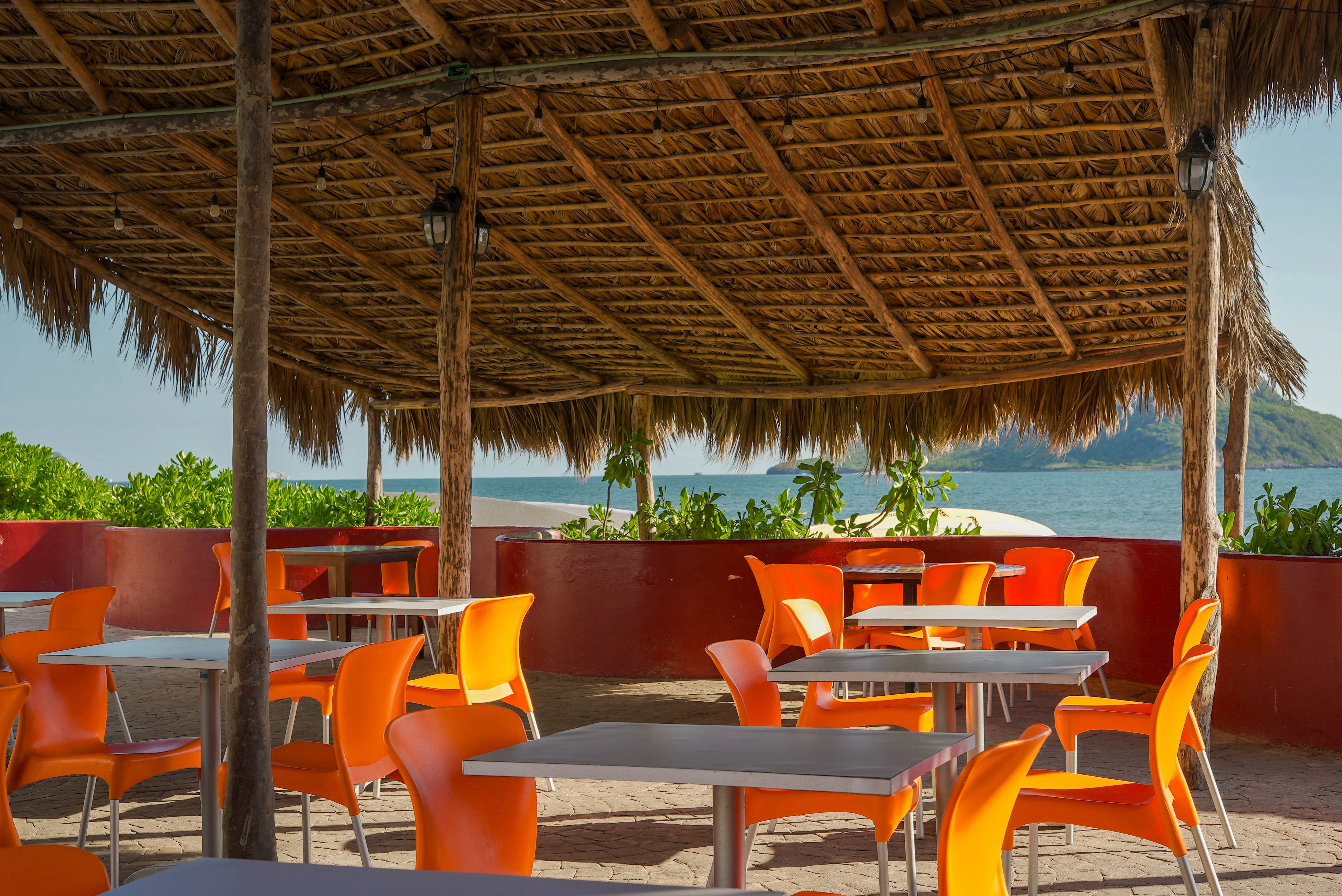 Sillas y mesas en palapa vista al mar en Hotel Sunset Palace Mazatlán