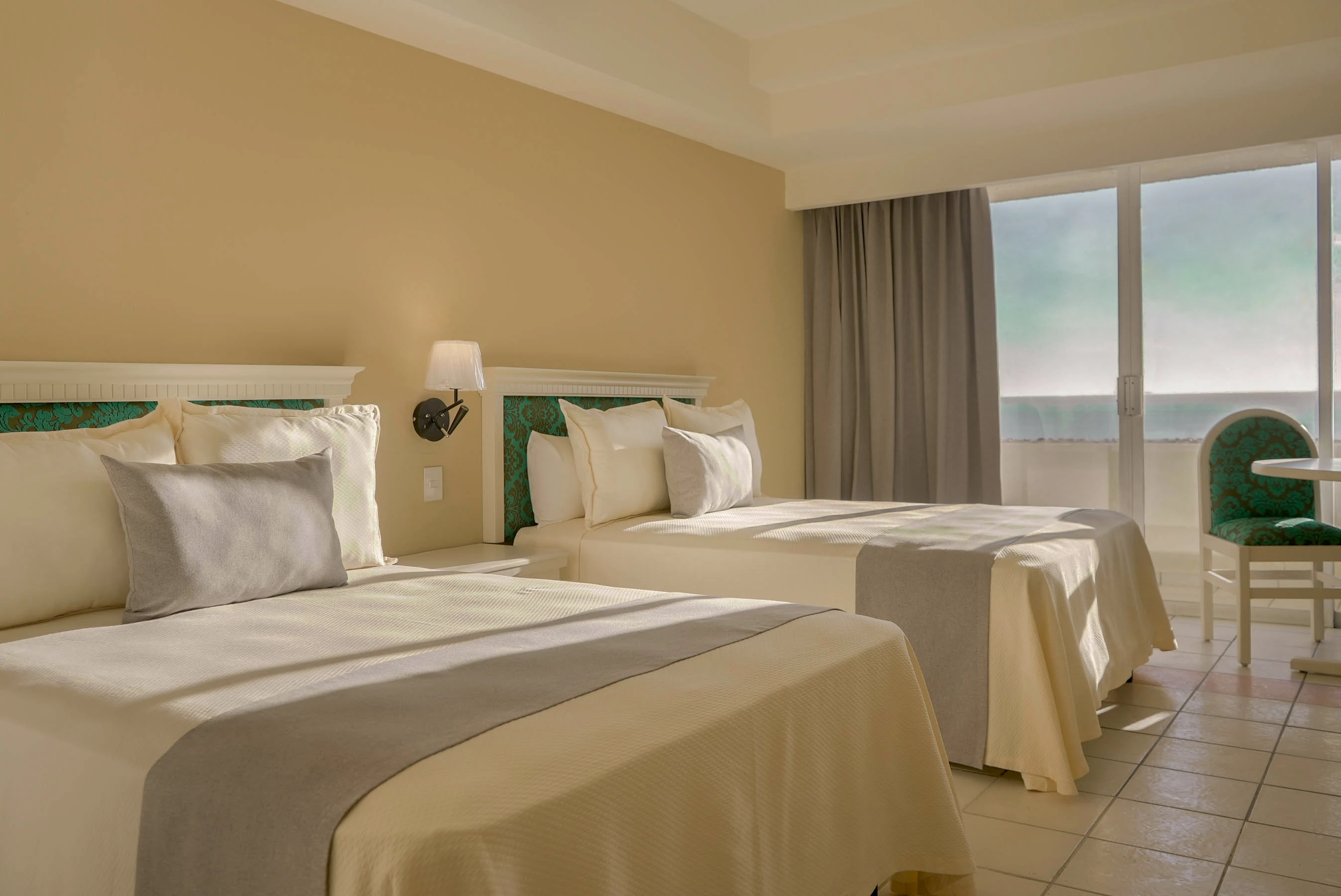 habitación estándar doble con dos camas matrimoniales, con balcón vista a la ciudad del hotel sunset palace mazatlán